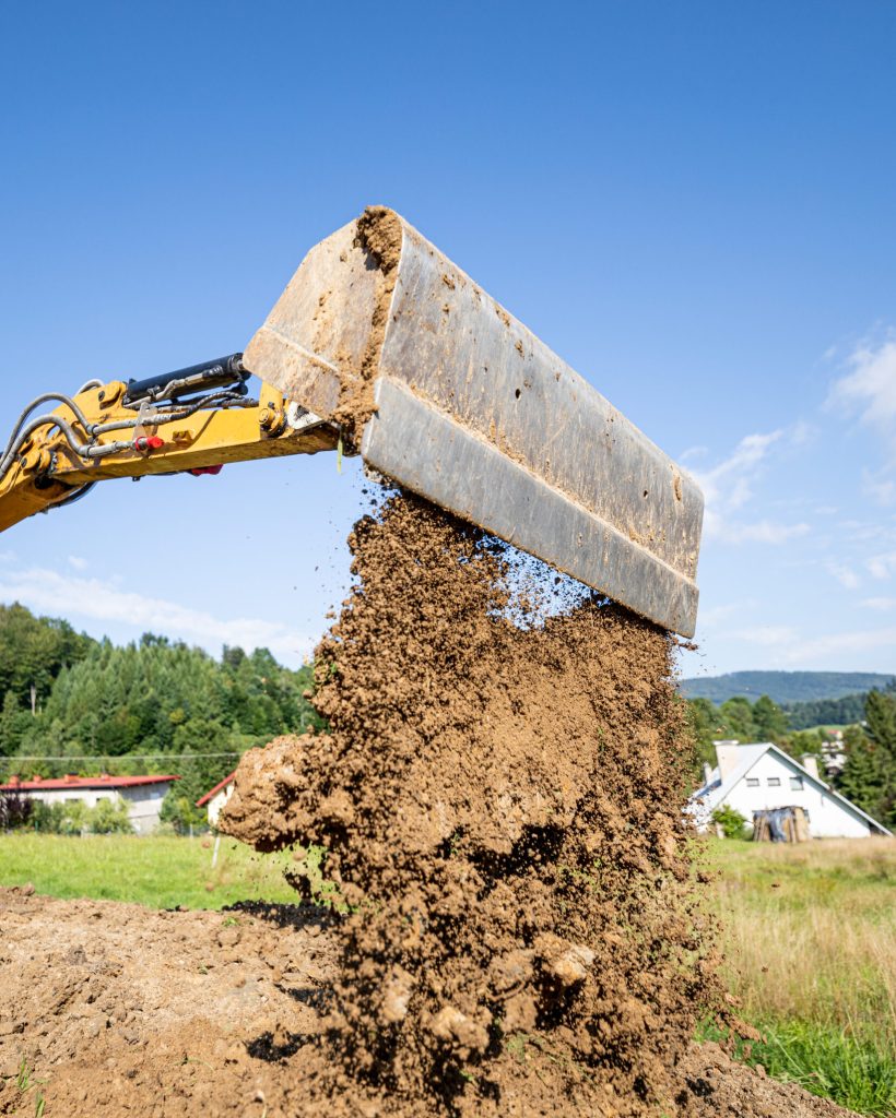 Mini excavator digging preparing ground under home garden